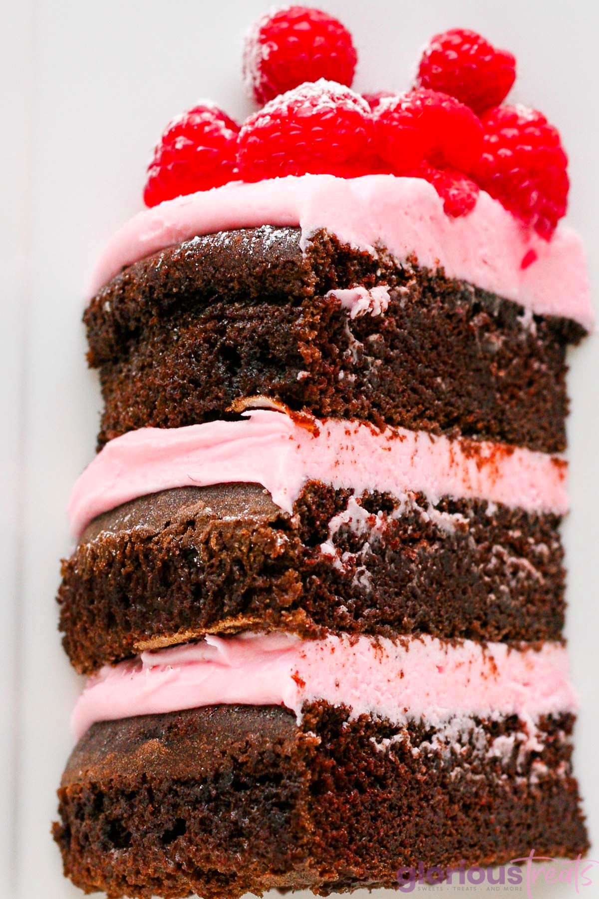 one generous three layer cake slice made with raspberry buttercream and fresh raspberries.