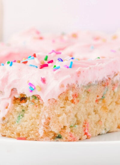 A slice of funfetti sheet cake on a white plate.