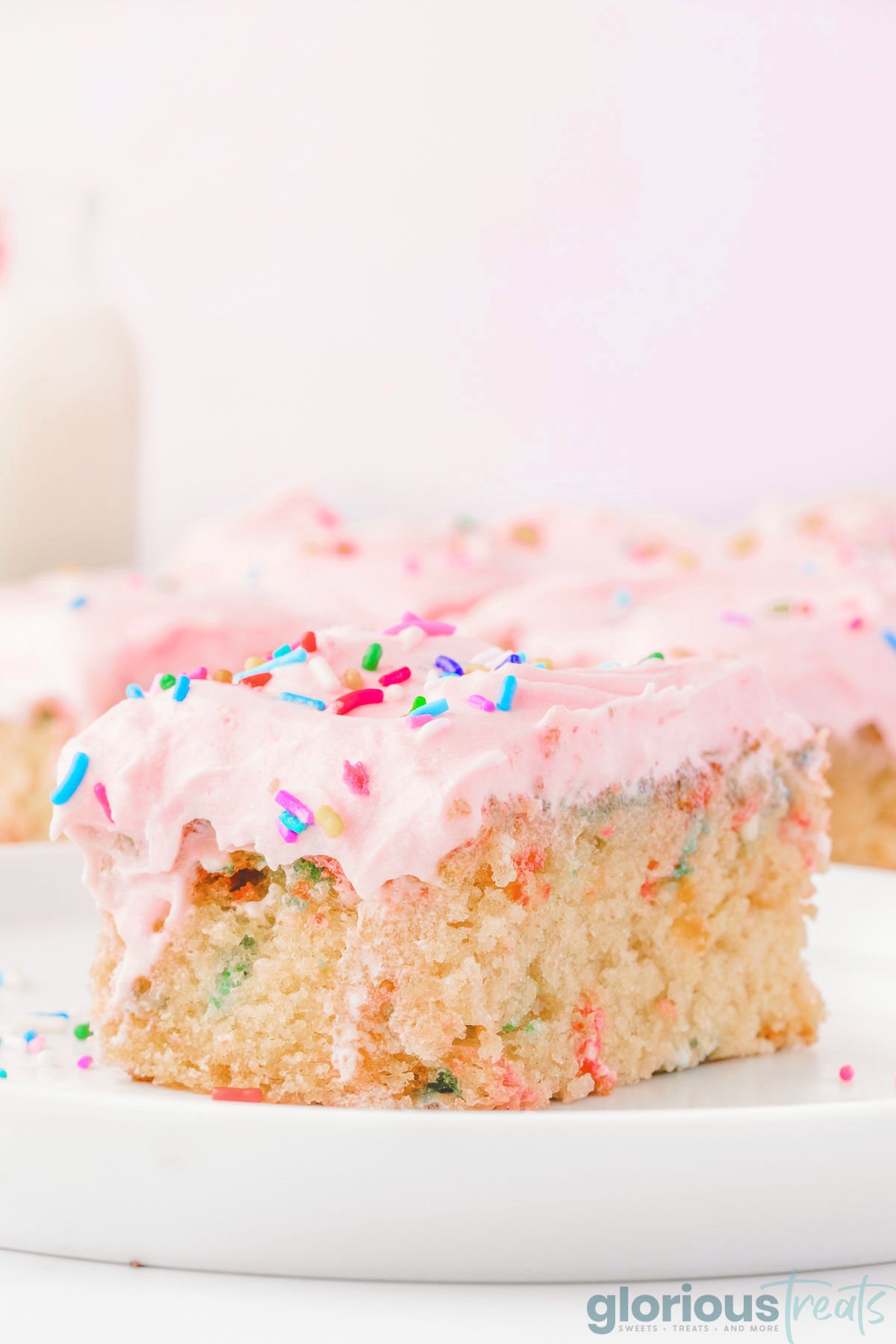 A slice of funfetti sheet cake on a white plate.