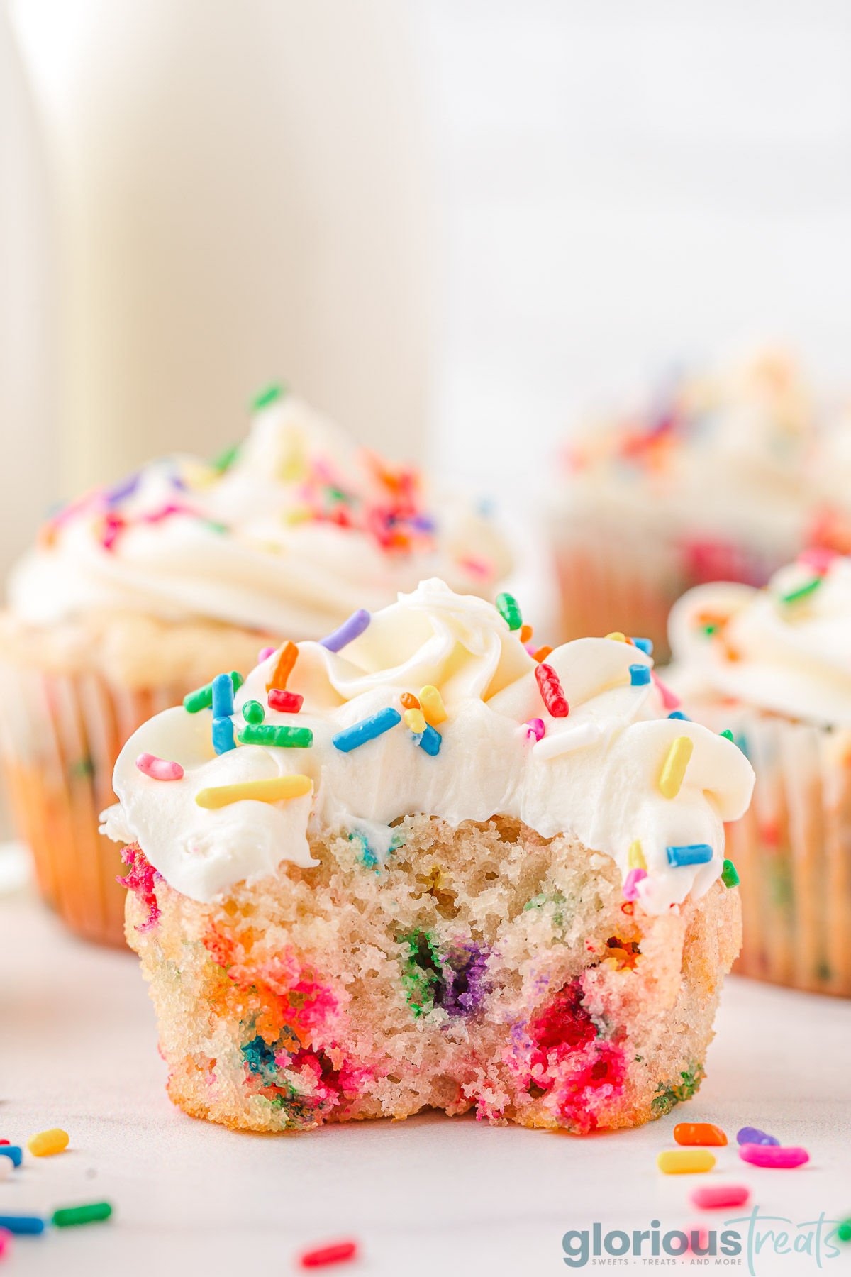 A side view of a birthday cupcake with a bite taken out of it.