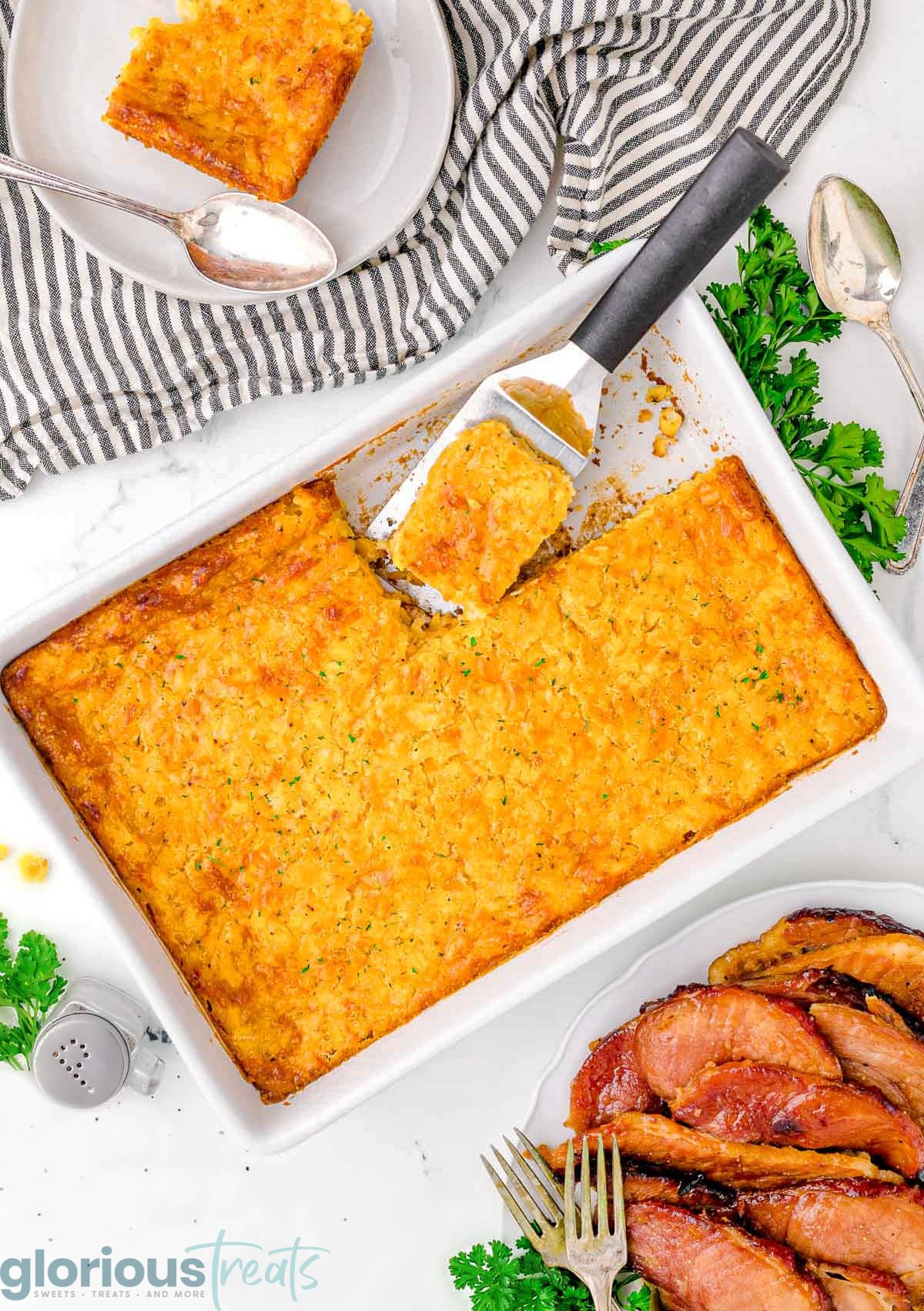 A top down view of cornbread casserole in a white pan.