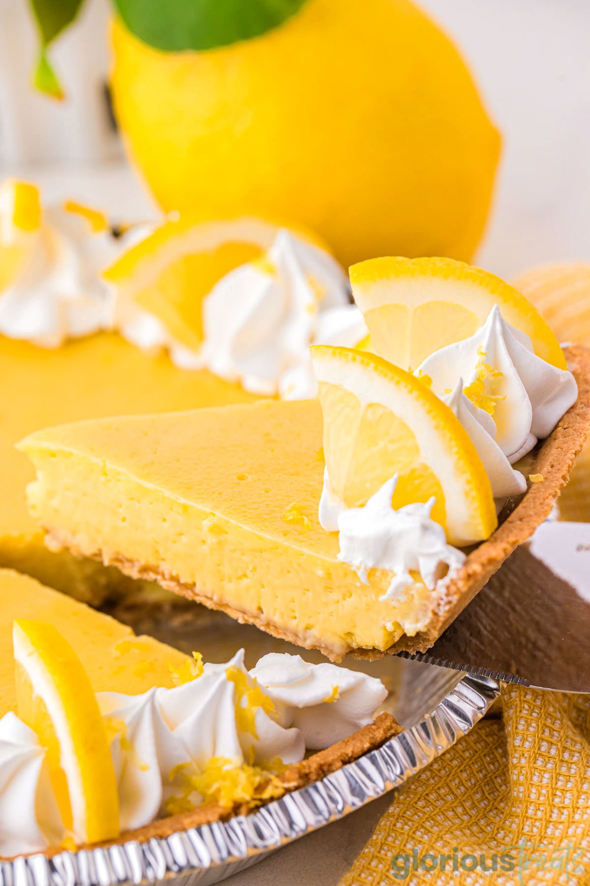 A metal pie serve holding a slice of lemon pie.