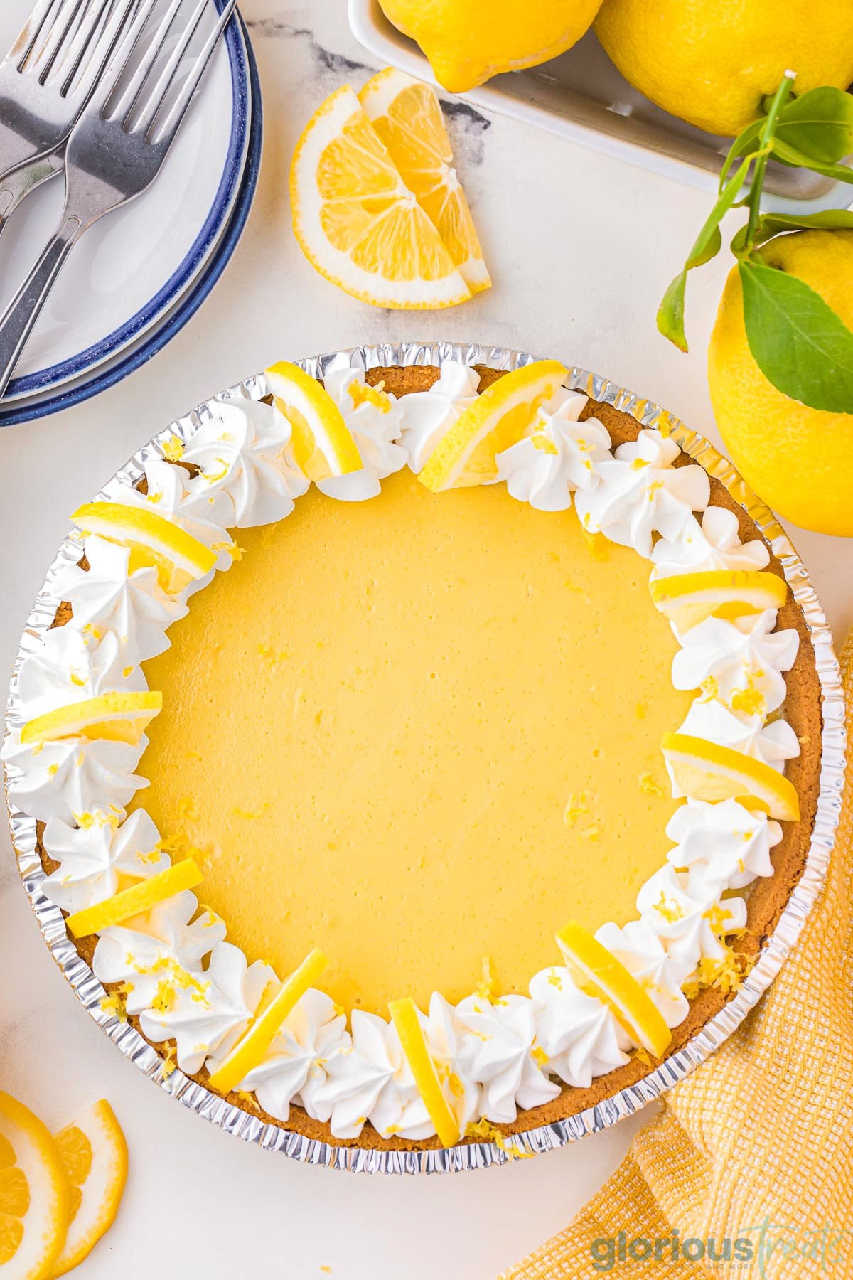 A top down shot of lemon pie on a white surface.
