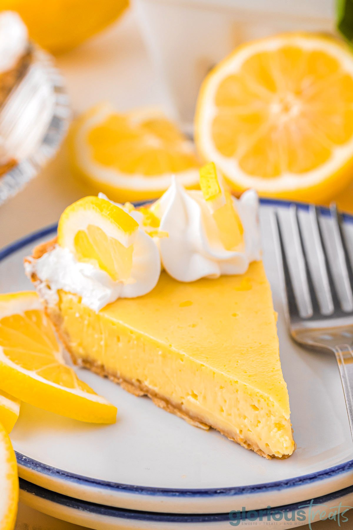 A slice of lemon pie on a stack of white plates.