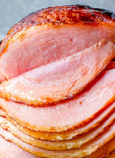 Apple cider ham glaze recipe on spiral sliced ham on platter.