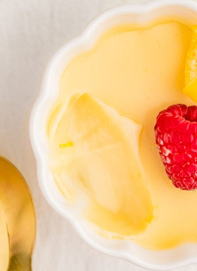 Lemon Posset in a decorative white bowl with a scoop taken out of it.