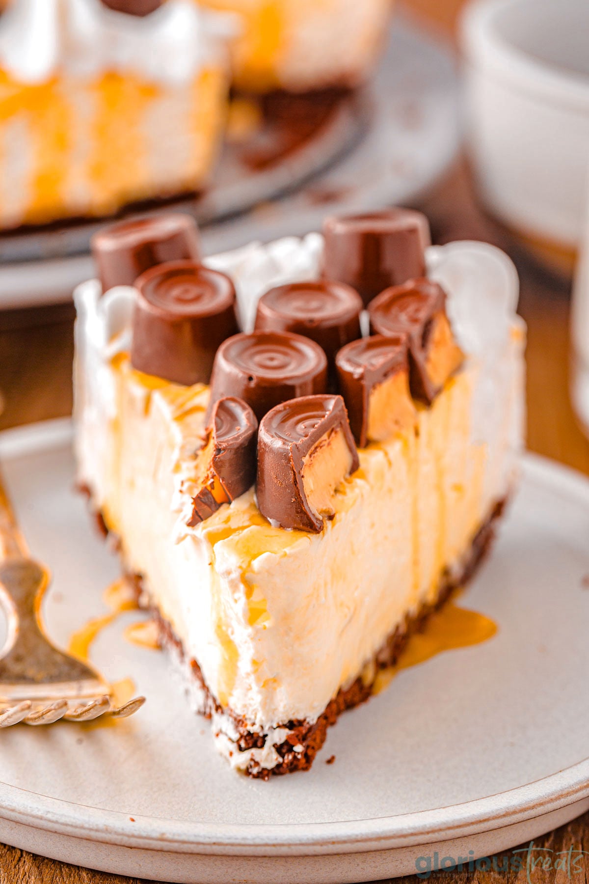 Caramel Cheesecake recipe sliced and placed on small dessert place with fork next to it.